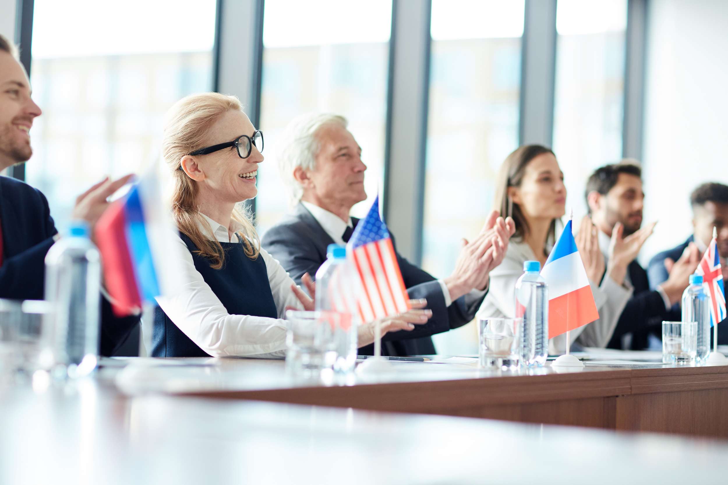 Odborníci s európskymi vlajkami rokujú pri konferenčnom stole